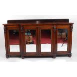 A late Regency rosewood breakfront side cabinet, having an associated ledgeback over a plain frieze,