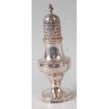 A George III silver pedestal lighthouse pepperette, having bright cut and finial topped pierced dome