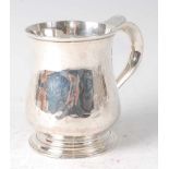 An early George II silver bell shaped small tankard, being later monogrammed, raised on an ogee