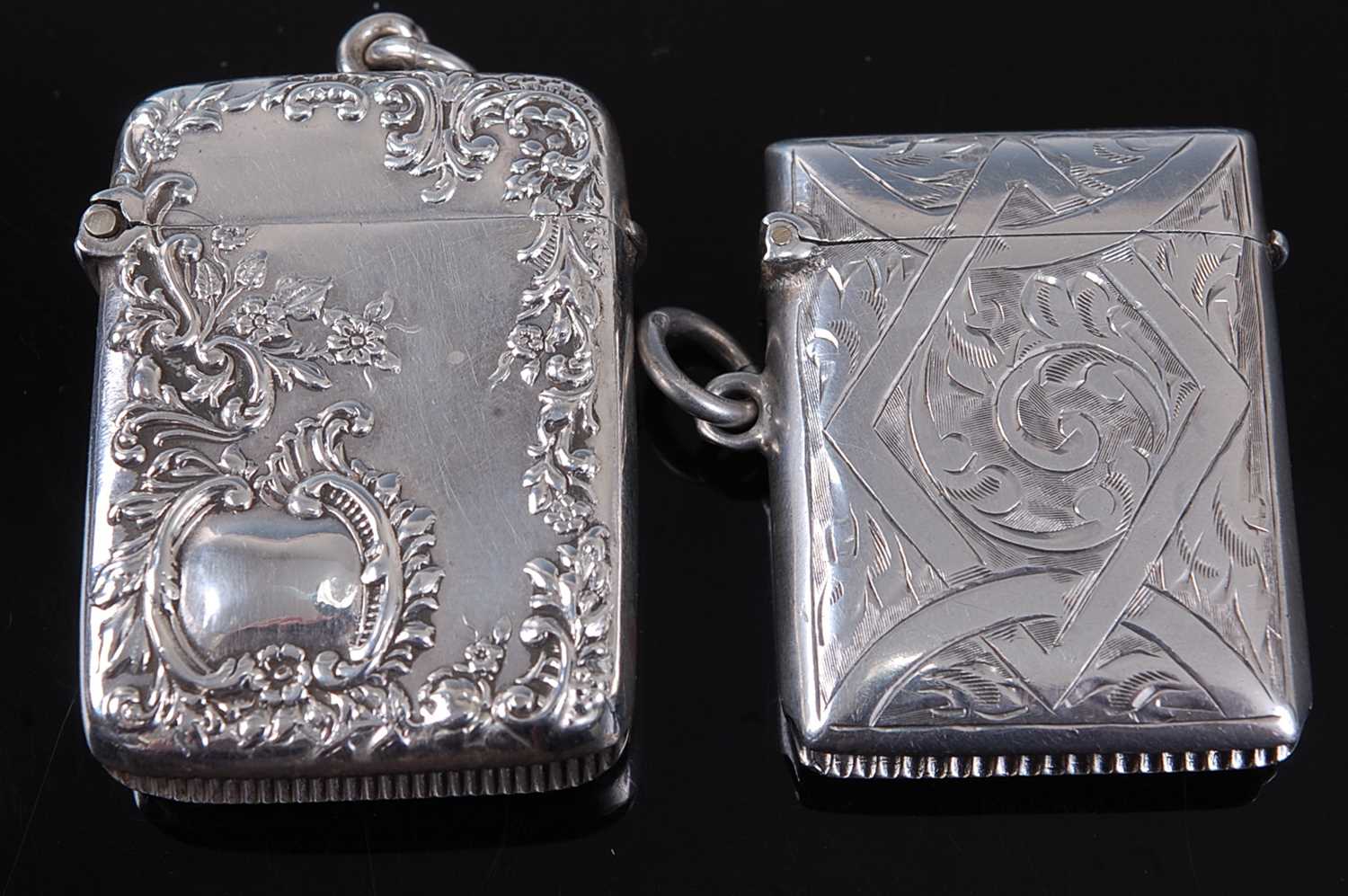 A late Victorian silver vesta, of hinged rectangular form, relief decorated with flowers and C-