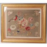 An 18th century felt and wool work panel depicting a robin upon a flowering branch, further