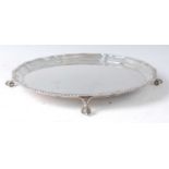 A late Victorian silver salver, having a gadrooned piecrust rim, raised on three claw and ball feet,