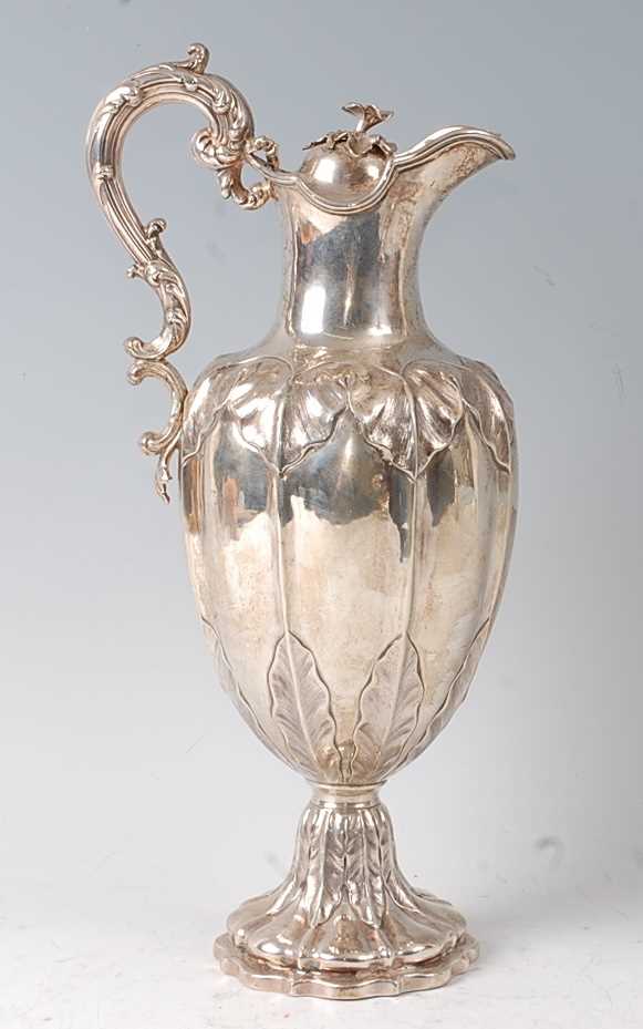 A Victorian silver claret jug, the lobed body with chased floral decoration, raised on a spreading