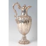 A Victorian silver claret jug, the lobed body with chased floral decoration, raised on a spreading