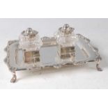 An Edwardian silver desk stand, of shaped rectangular form, with shell capped rim, twin glass