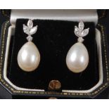 A pair of white metal, pearl and diamond drop earrings, the earrings each featuring a pearl drop