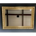 A pair of contemporary gilt-framed wall mirrors, the moulded frames incorporating foliage and