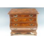 A reproduction miniature mahogany bombe form chest of drawers, 35 cm high