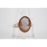 An antique carved shell cameo ring depicting the profile of a fashionable young lady, millegrain and