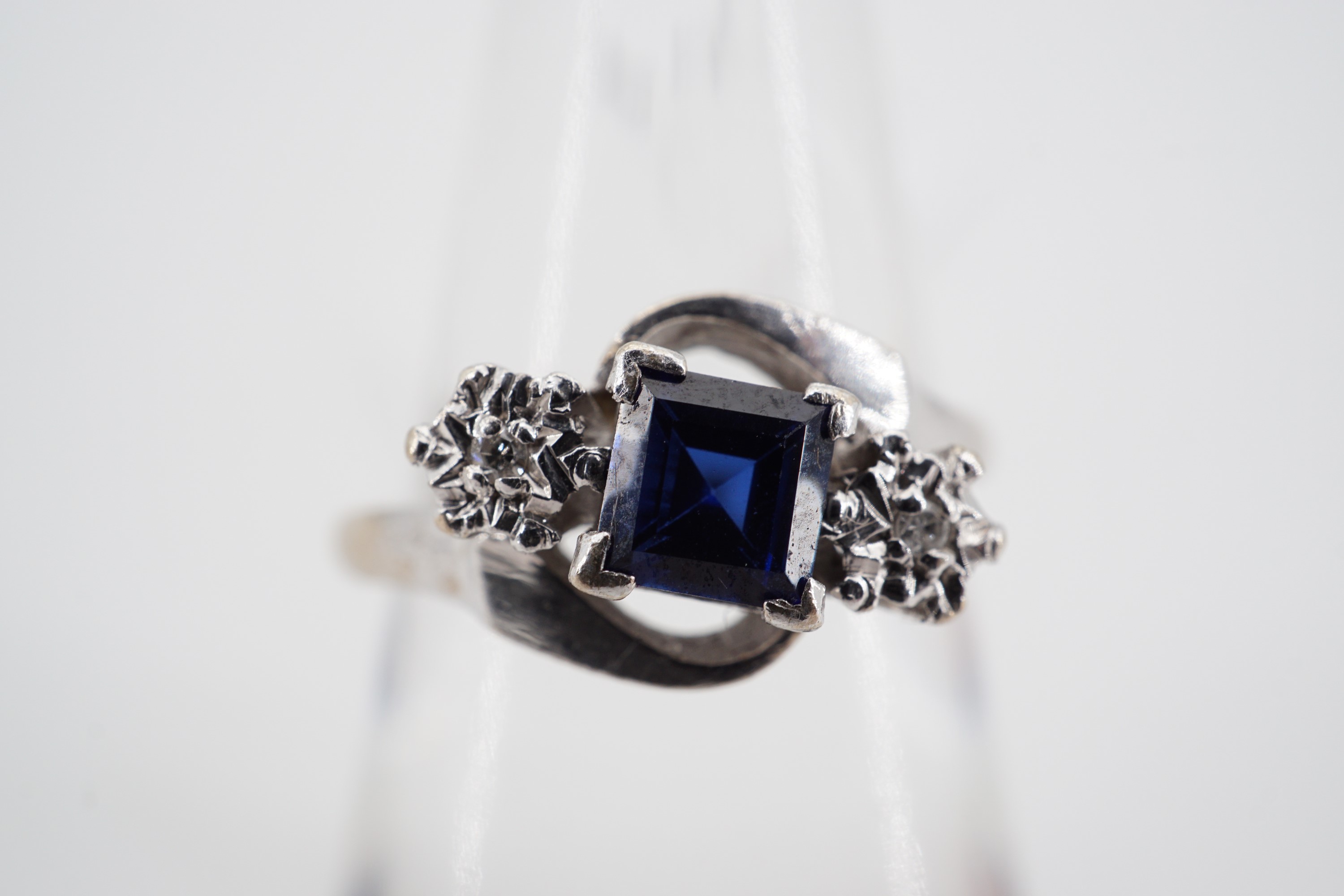 A sapphire and diamond twist set dress ring with central princess cut sapphire of approximately .