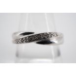 A contemporary 9ct white gold and diamond eternity ring, the face being twist-set in a saltire