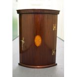 A reproduction inlaid mahogany bow-fronted corner cabinet, 67 cm high