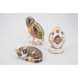 Two Royal Crown Derby paperweights and a Royal Crown Derby egg and stand