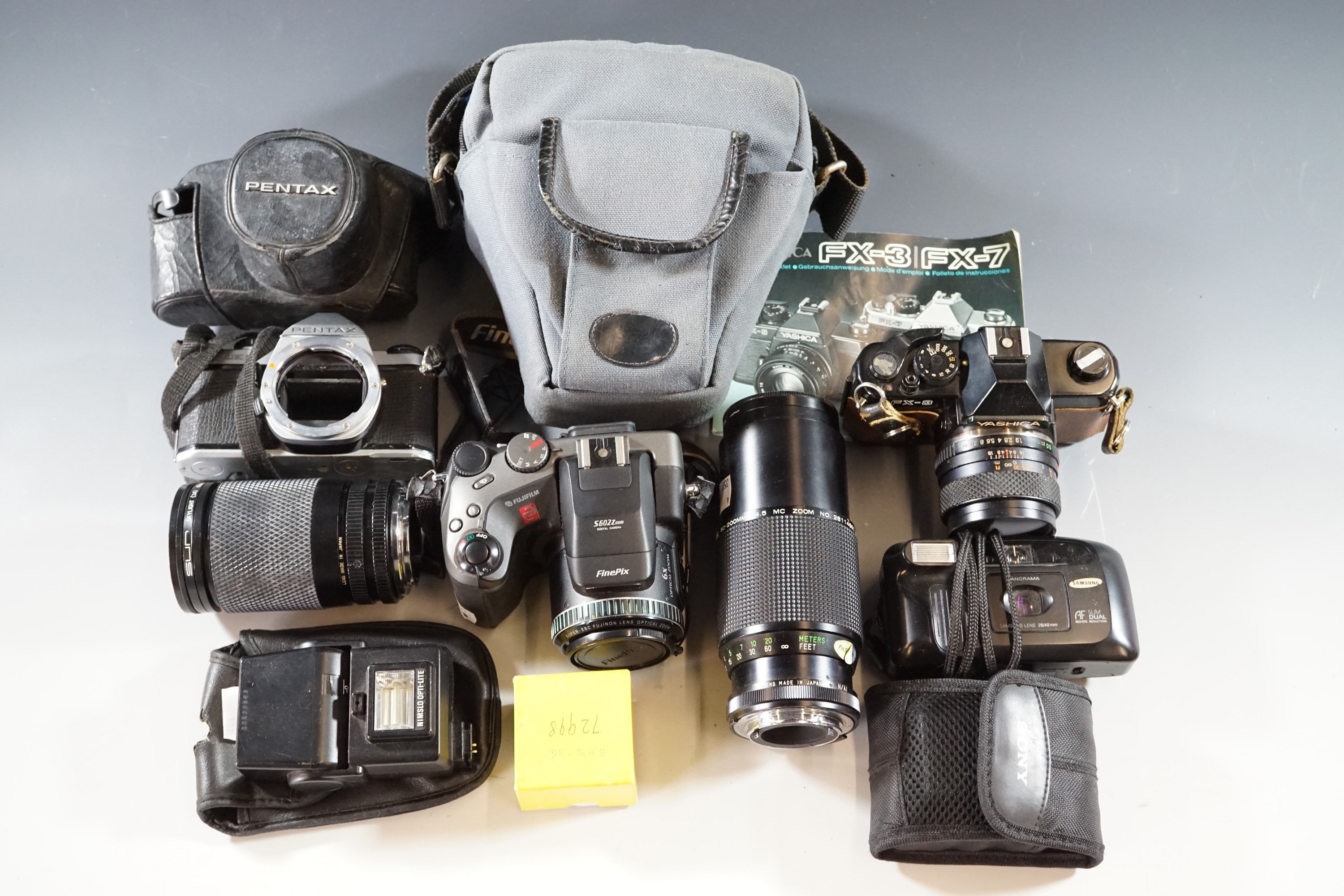 A quantity of vintage cameras and lenses, including Fujifilm FinePix S602 with digital zoom, Yashica