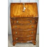 A quality reproduction Georgian serpentine-fronted fall-front bureau of diminutive stature, in