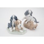 Two Nao figurines modelled as puppies at play, 14 cm and 11 cm high