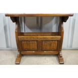 An oak linen-fold panelled occasional table / magazine rack