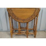 A diminutive carved oak gate-leg occasional table, 70 cm high