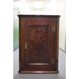 An early 18th Century marquetry-inlaid oak hanging corner cabinet, 78 cm high.