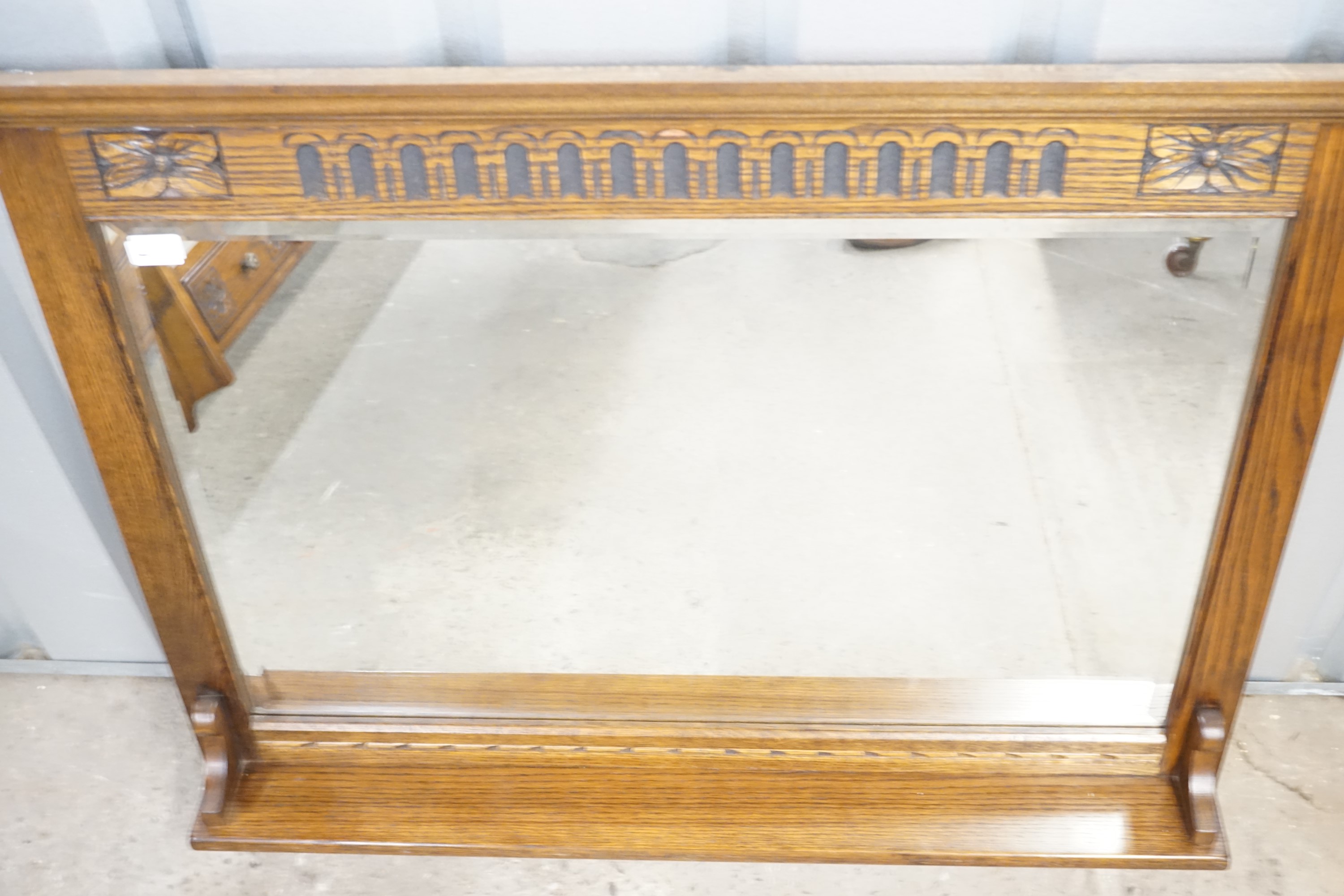 A carved-oak overmantel mirror with integral shelf and bevel-edged plate, 107 cm x 92 cm high