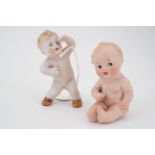 A vintage Goebel Kewpie bisque "piano baby" and one other similar