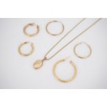 An assortment of 9ct gold and yellow metal hoop earrings, and a 9ct gold pendant locket, the