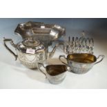 A three-piece electroplate tea set, basket and toast rack