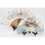 Two 19th Century hand fans, each transfer printed and hand tinted, one having carved bone sticks,