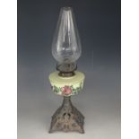 A Victorian oil lamp, having an enamelled glass reservoir and cast pyramidal base