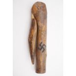 A primitive carved wooden pipe tamper bearing a swastika