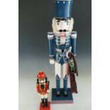 A large contemporary painted wooden toy soldier together with a smaller example, 88 cm x 36 cm