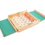An early 20th Century wooden travelling chess board with turned bone pieces, 9 cm x 17 cm x 6 cm