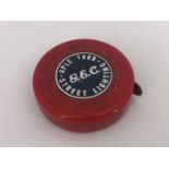 A 1968 GEC Street Lighting red plastic and steel advertising tape measure, 4.5 cm diameter