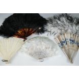 A collection of vintage hand fans, including a bone brise fan, and ostrich feather examples