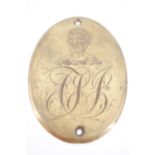 An early 19th Century engraved brass plaque incorporating an armorial crest and monogram, 8 cm x 6