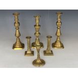 A pair of Victorian brass push-eject candlesticks, 28 cm, and other candlesticks