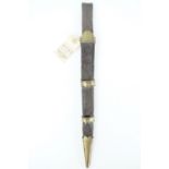 An 18th Century Scottish dirk scabbard, of black hide bearing tooled decoration, the brass locket,