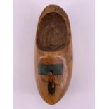 A carved and painted wooden clog, bearing a Royal Naval Division device, being the work of an RND