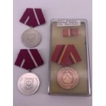 An East German Medal of Merit of the Combat Groups of the Working-Class and two Medals for