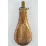 A Victorian Bartram copper and brass powder flask, the bag shaped body relief-decorated in a