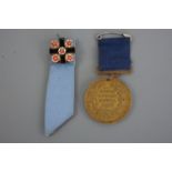 An Edwardian Cumberland Voluntary Schools attendance medal together with an enamelled arms of the