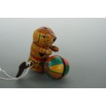 A tinplate clockwork toy dog and ball, (working)