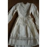 A 1920s girls dress, having a Peter Pan collar, full length sleeves with button cuffs, integral