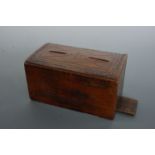 An antique wooden money box and sundry coins