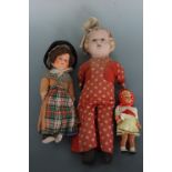 Two 1920s dolls, one in period polka dot trouser dress, the other in traditional Welsh costume,