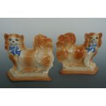 A pair of reproduction 19th Century earthenware standing spaniels with blue ribbon collars, 19 cm