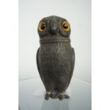 A Victorian novelty caster or pounce pot modelled as an owl, in pewter or Britannia metal with glass