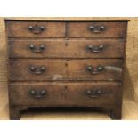 A George III oak chest of two short over three long drawers, having brass bale handles and square