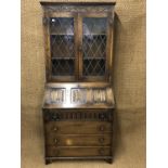 A leaded-glazed and linen-fold panelled oak bureau bookcase of diminutive stature, 78 cm x 161 cm