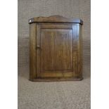 A reproduction oak hanging corner cabinet of diminutive stature, 58 cm x 66 cm high